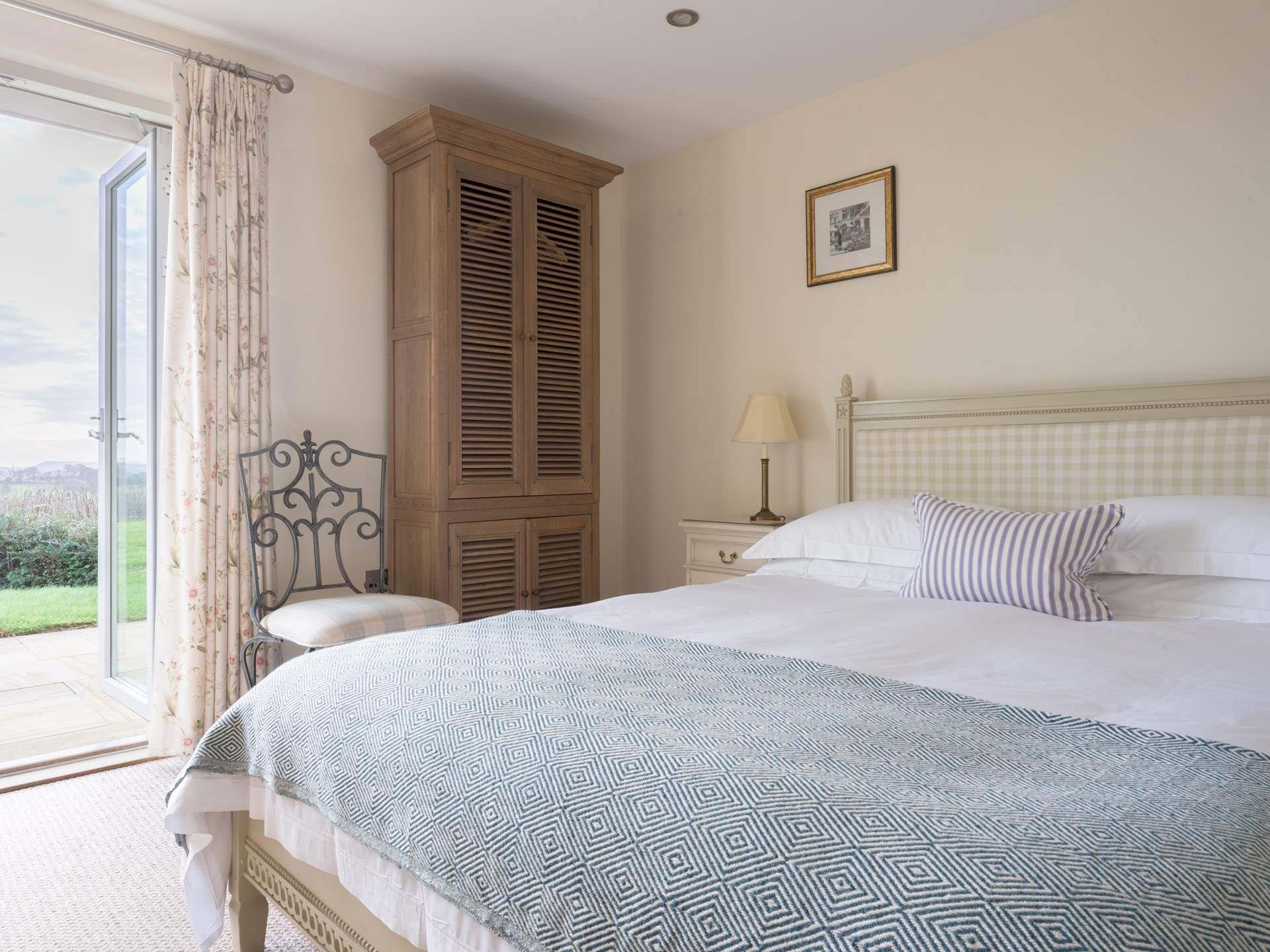 Bedroom 1 is a calm and restful space with a glorious king-size bed and doors onto the patio. 