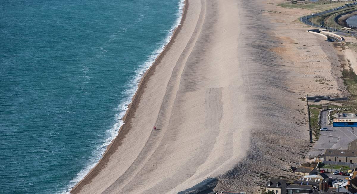The striking Chesil Beach with Weymouth along the bay.