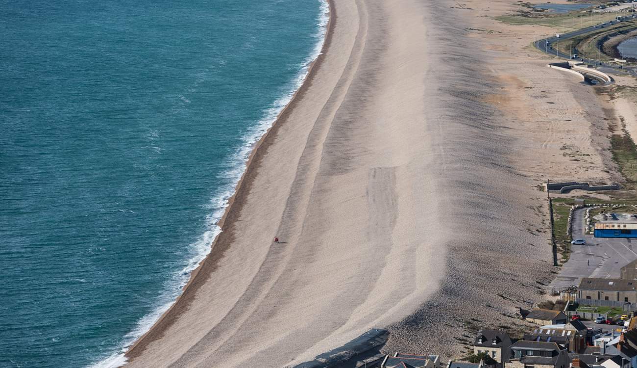 The striking Chesil Beach with Weymouth along the bay.
