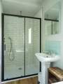 The bathroom is very spacious with a large shower enclosure and rainfall shower.