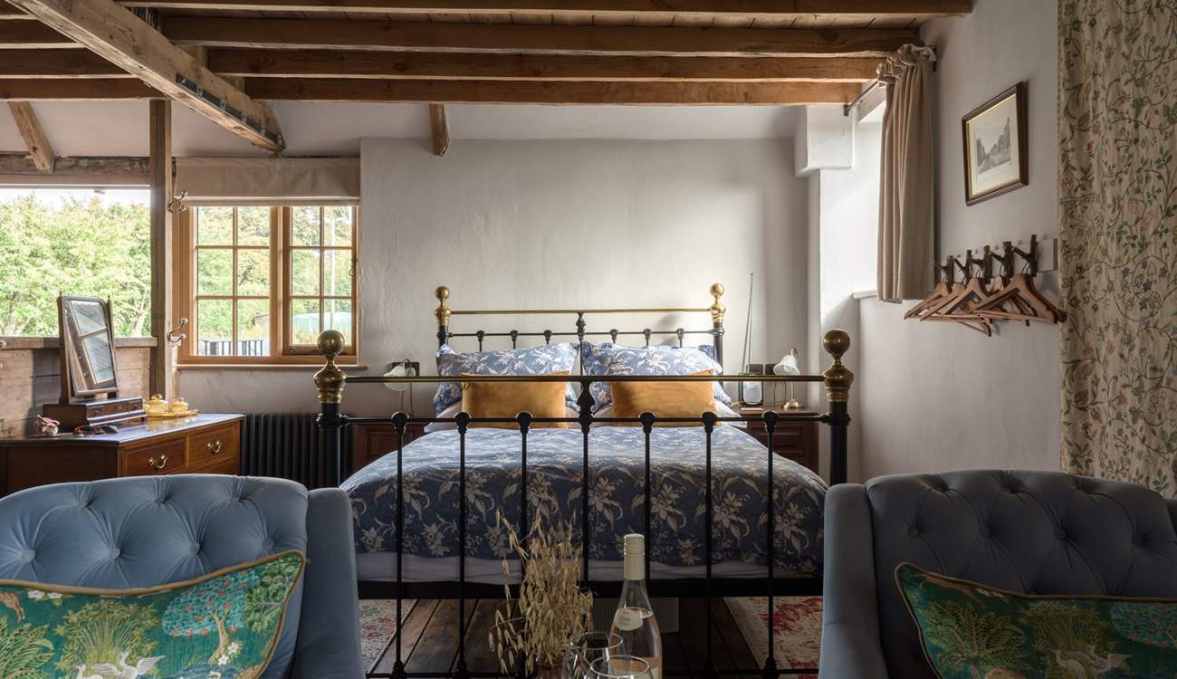 The king-size bed is beautifully presented with luxurious linens. You will sleep well here.