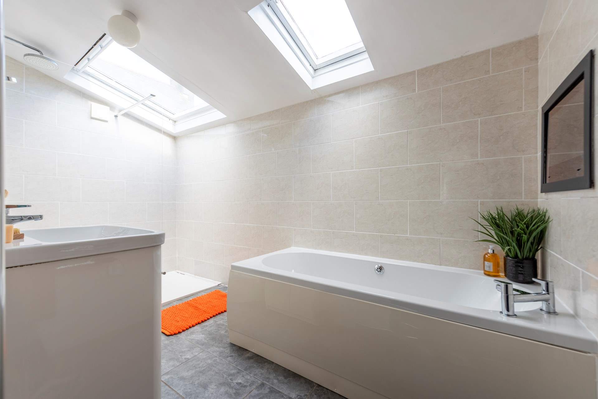 The en suite has a TV over the bath and a separate shower tray.