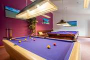There is a full-sized snooker table, pool table and dart board in this shared room.