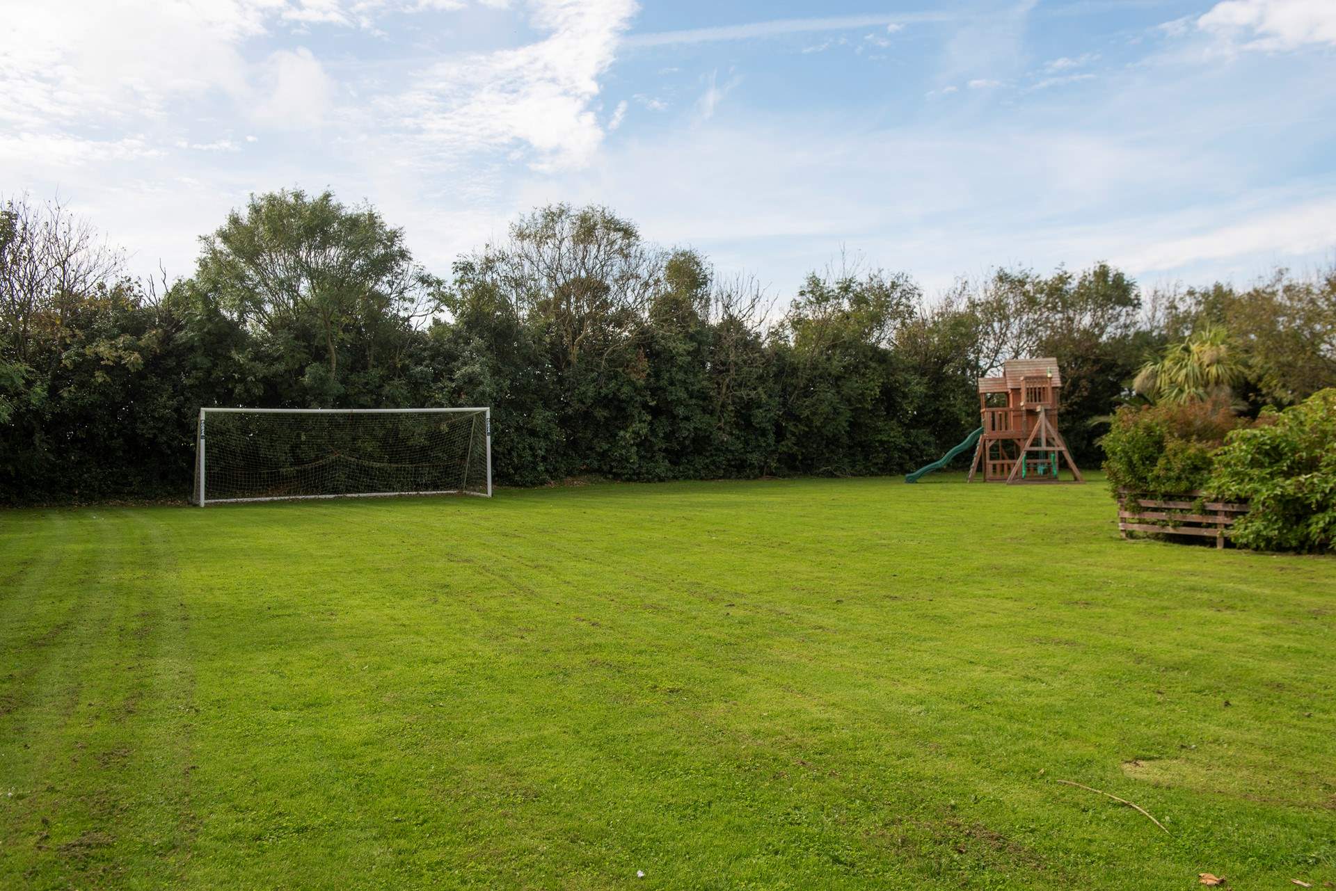 There is an enormous shared lawn and playhouse.