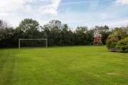 There is an enormous shared lawn and playhouse.