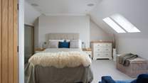 The second floor has a spacious bedroom with a king-size bed and an en suite bathroom. 