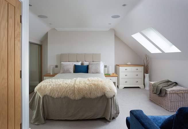 The second floor has a spacious bedroom with a king-size bed and an en suite bathroom. 