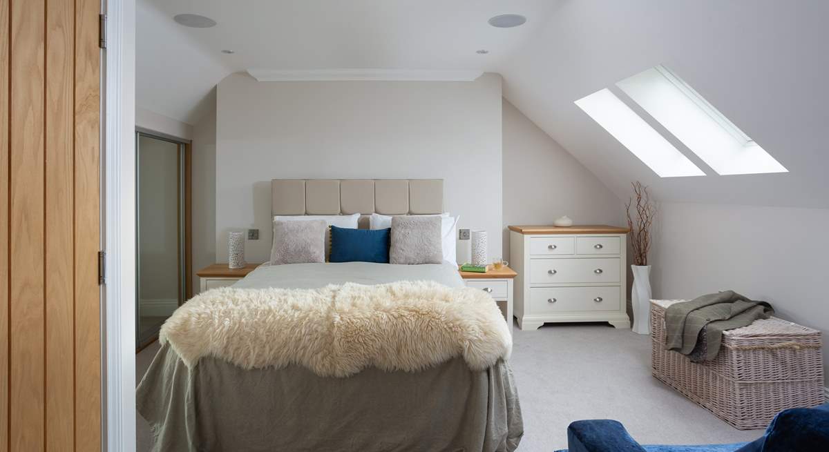 The second floor has a spacious bedroom with a king-size bed and an en suite bathroom. 