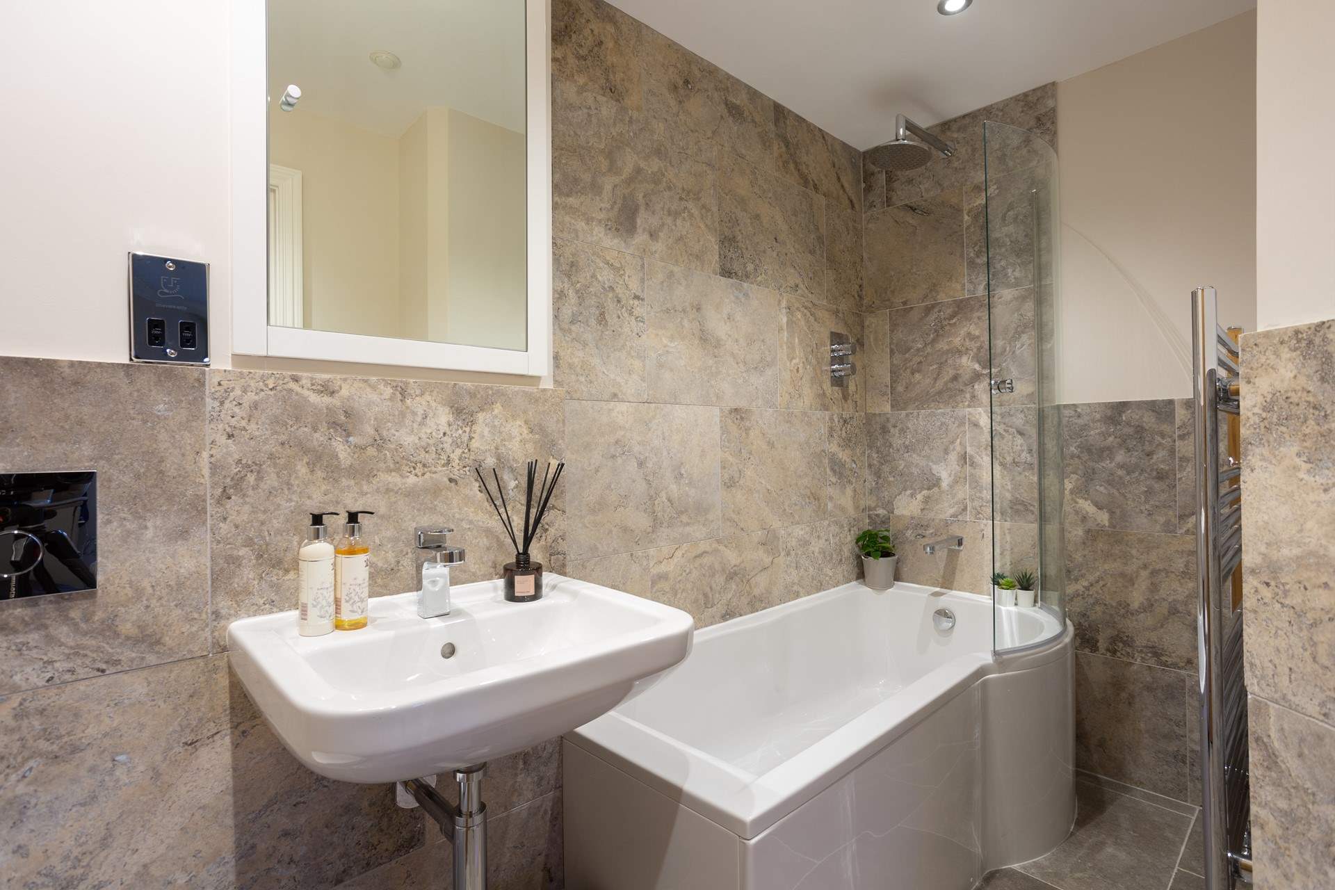 The luxury en suite bathroom has a rainfall shower over the bath. 
