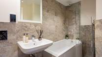 The luxury en suite bathroom has a rainfall shower over the bath. 