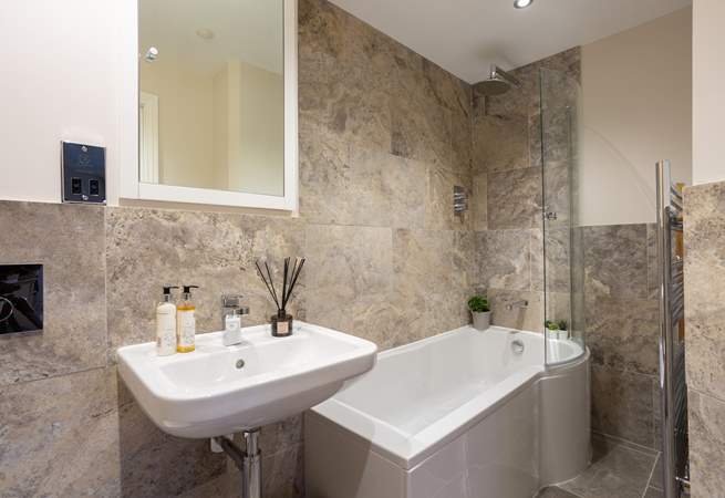 The luxury en suite bathroom has a rainfall shower over the bath. 