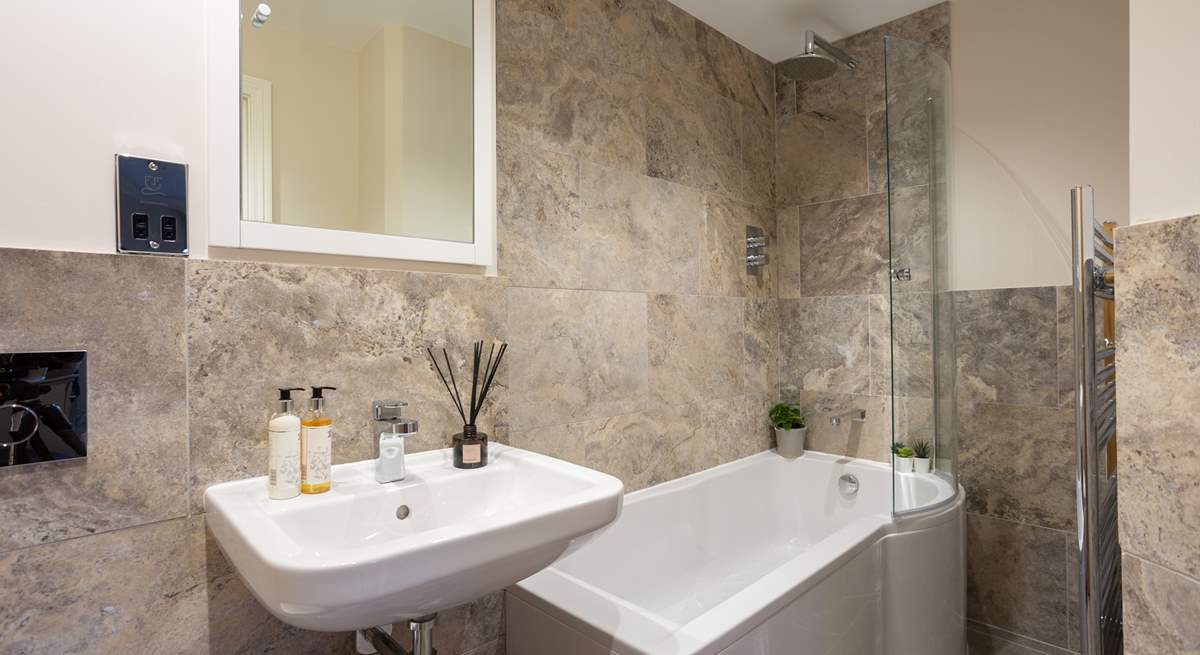 The luxury en suite bathroom has a rainfall shower over the bath. 