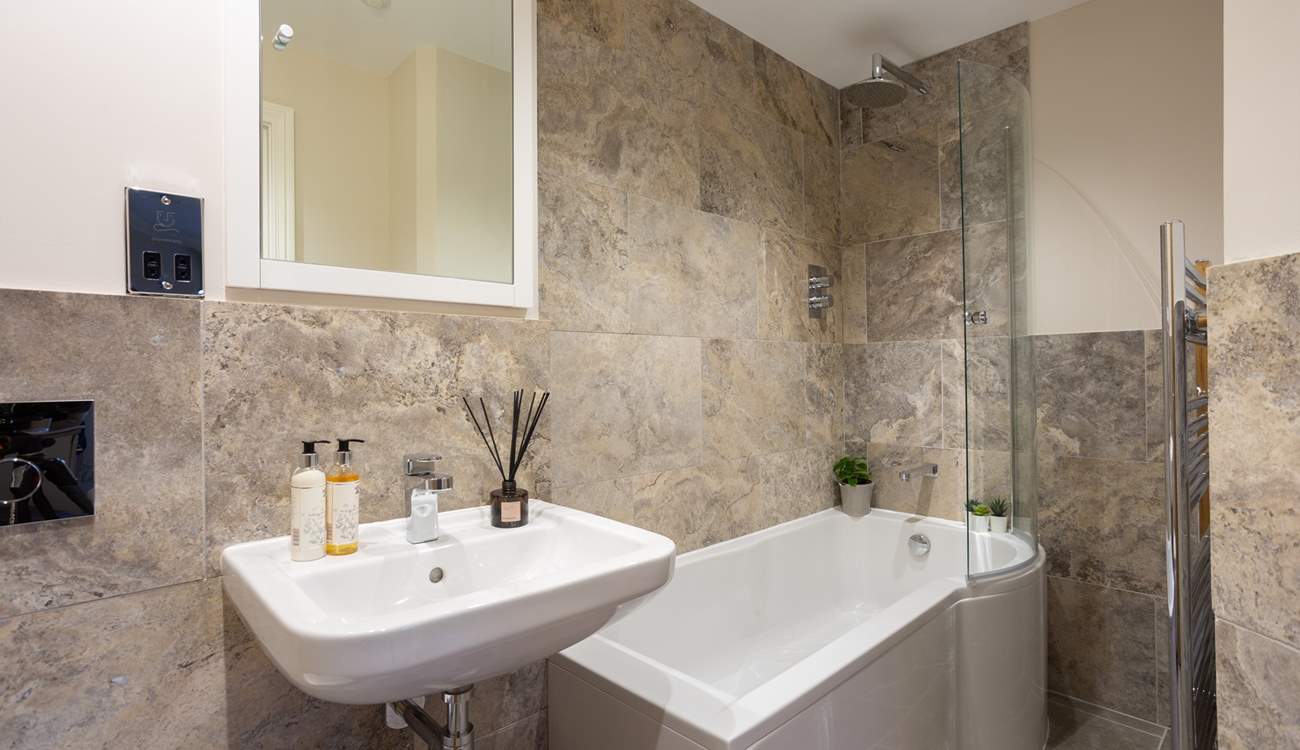 The luxury en suite bathroom has a rainfall shower over the bath. 