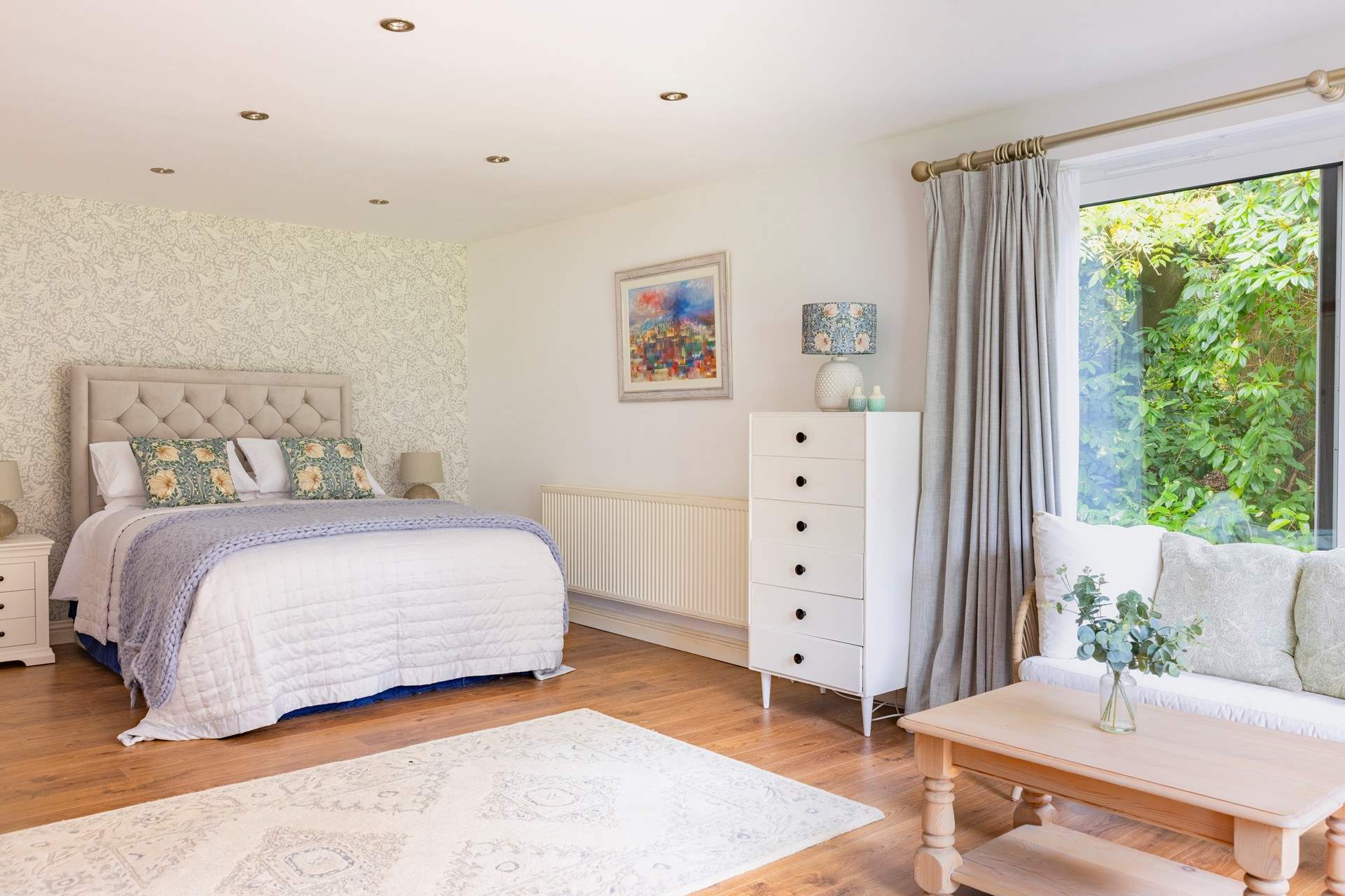 The ground floor bedroom with king-size double bed has a lounge-area and patio doors that open to a terrace and garden.