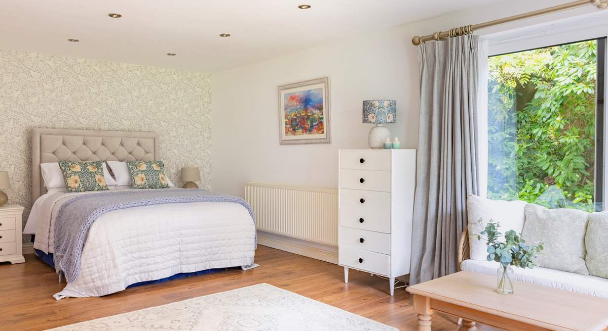 The ground floor bedroom with king-size double bed has a lounge-area and patio doors that open to a terrace and garden.
