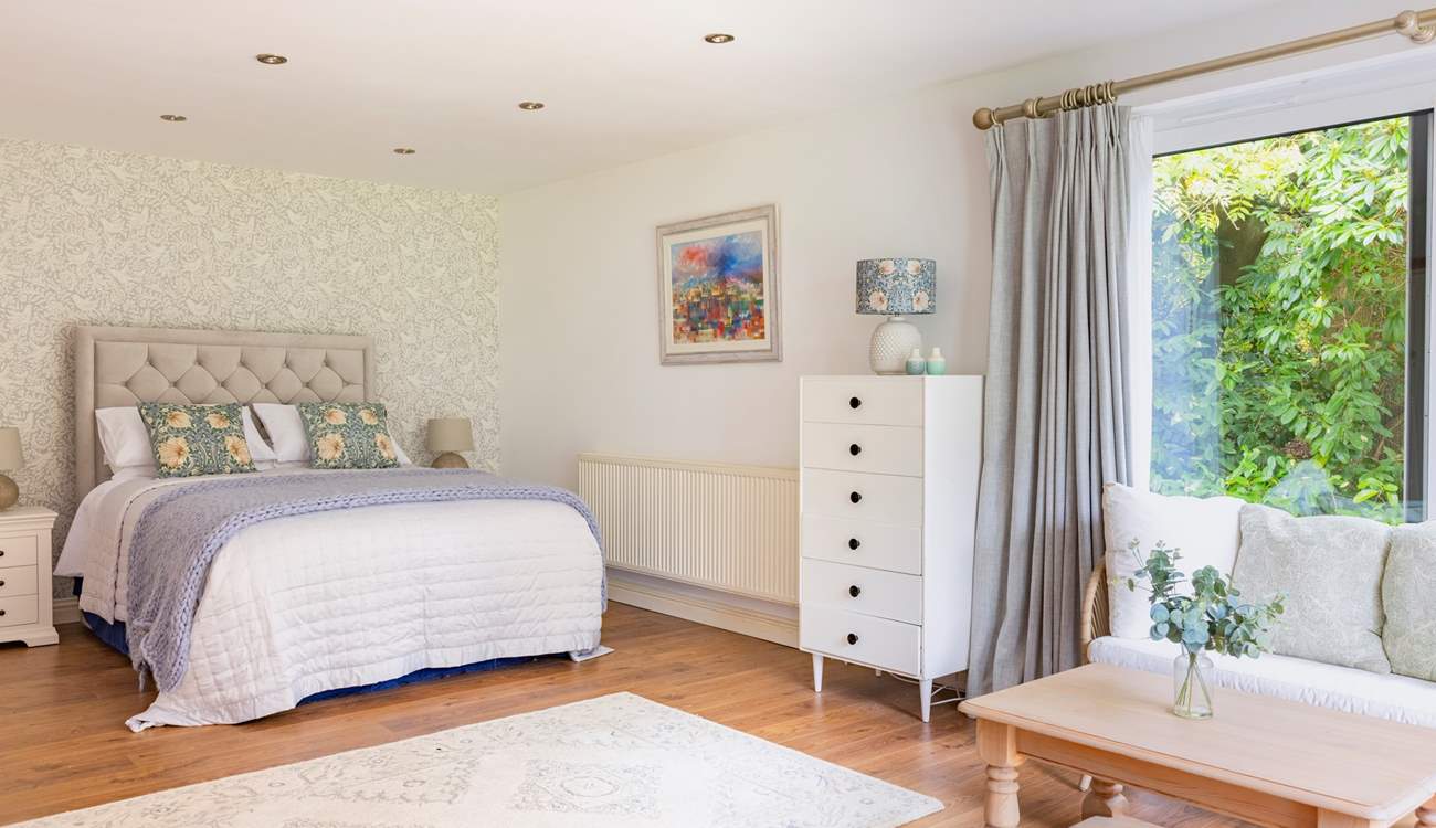 The ground floor bedroom with king-size double bed has a lounge-area and patio doors that open to a terrace and garden.