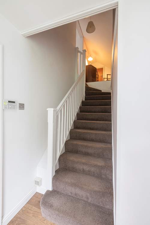 Stairs lead to the bedrooms on the first floor.