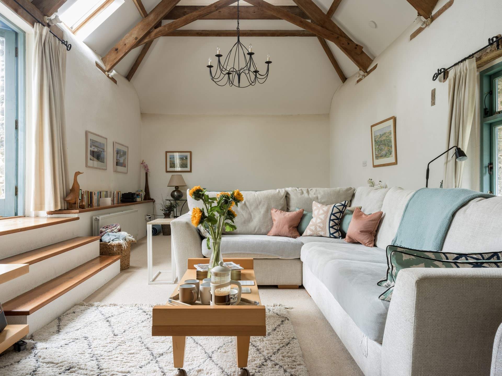 The light and airy sitting-room is on the first floor with vaulted ceiling and access to the patio area.