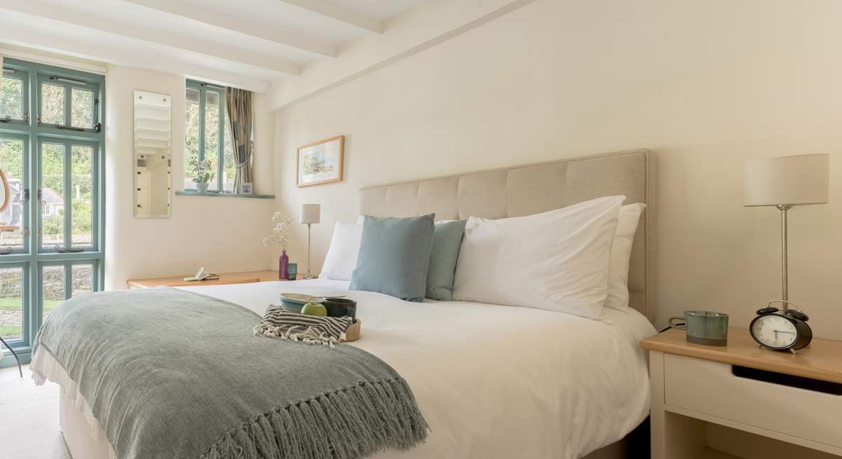 Bedroom 1 on the ground floor has a sumptuous king-size bed and views of the creek.