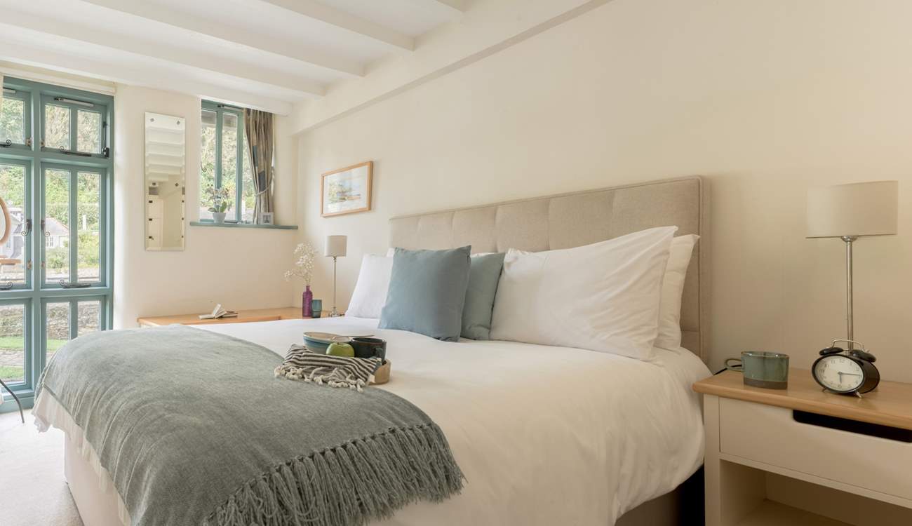 Bedroom 1 on the ground floor has a sumptuous king-size bed and views of the creek.