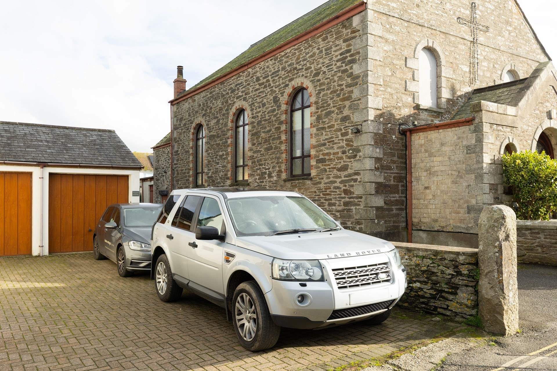 There is parking for two medium-sized cars, parked nose to tail. 