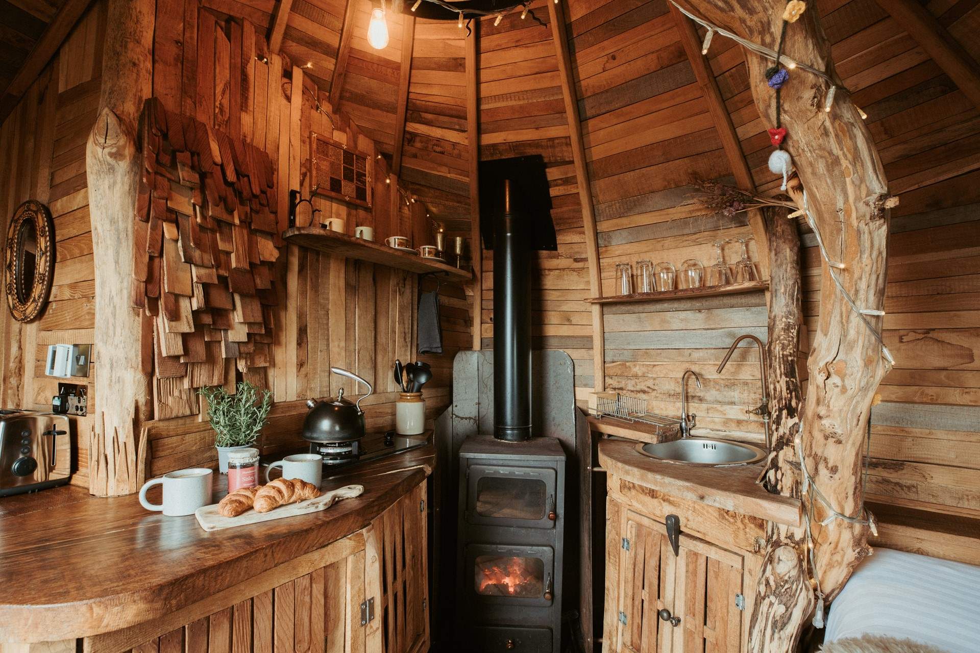 Natural wood panels line the walls and the comforting glow of the wood-burner fills the hideaway. 