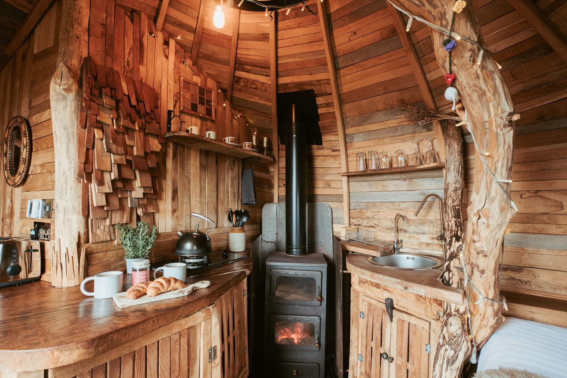 Natural wood panels line the walls and the comforting glow of the wood-burner fills the hideaway. 