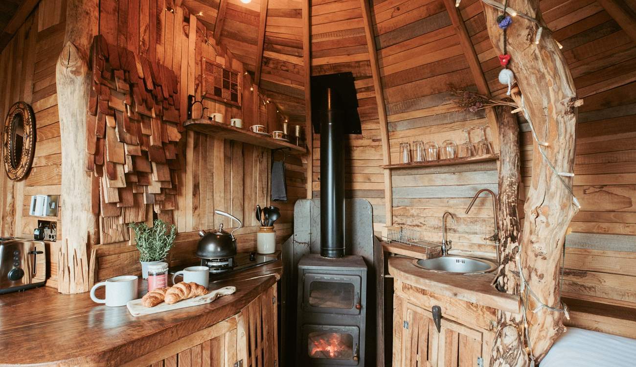 Natural wood panels line the walls and the comforting glow of the wood-burner fills the hideaway. 