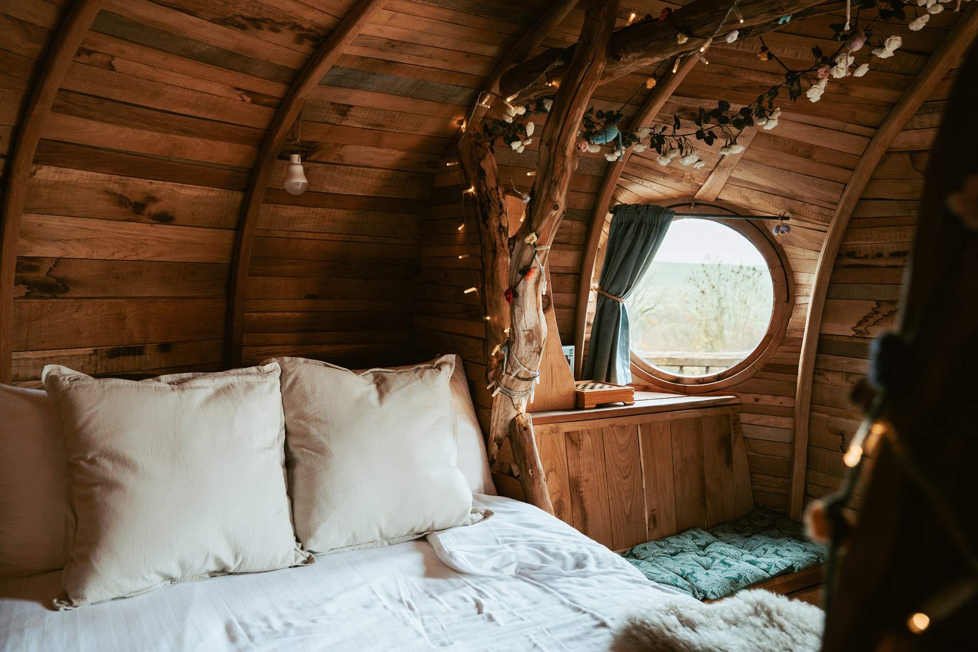 Sleep beneath the fairy-light wrapped branches in luxury linens. 