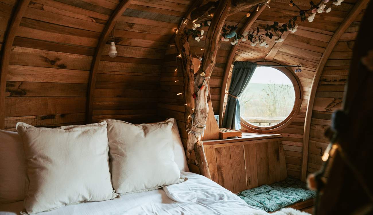 Sleep beneath the fairy-light wrapped branches in luxury linens. 