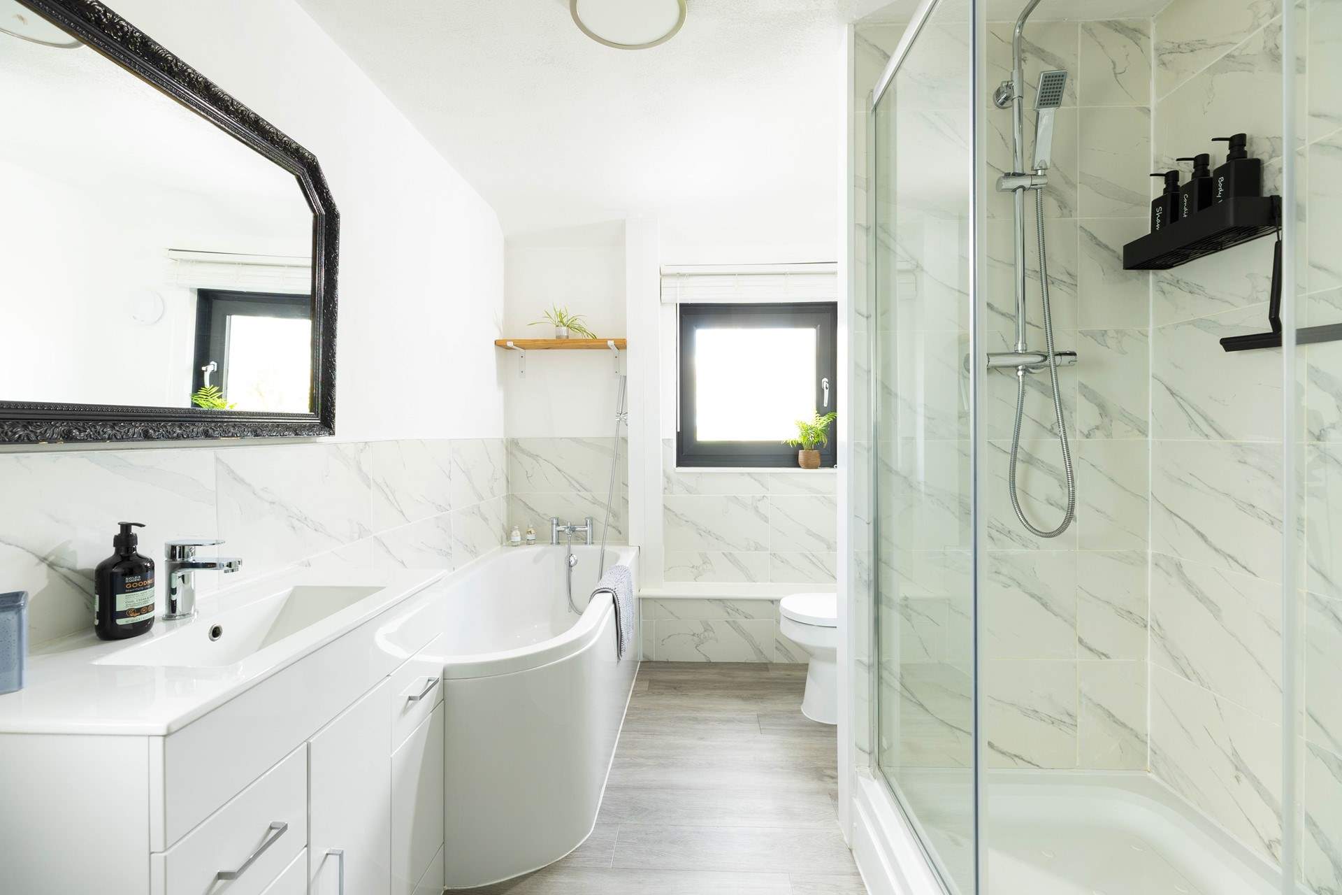 The stylish bathroom has a bath and a shower. The bathroom is located on a half-landing.