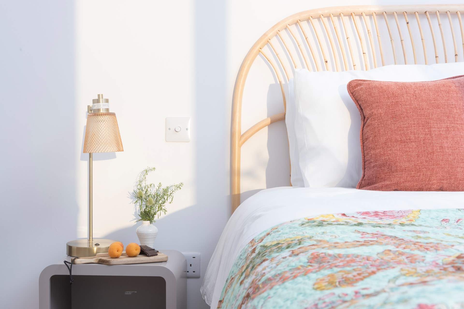 The gorgeous bedspread brings a beautiful pop of colour to the room.