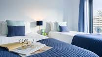 Decorated in coastal tones, the twin room will work for adults or children. There's also French doors out to the garden.