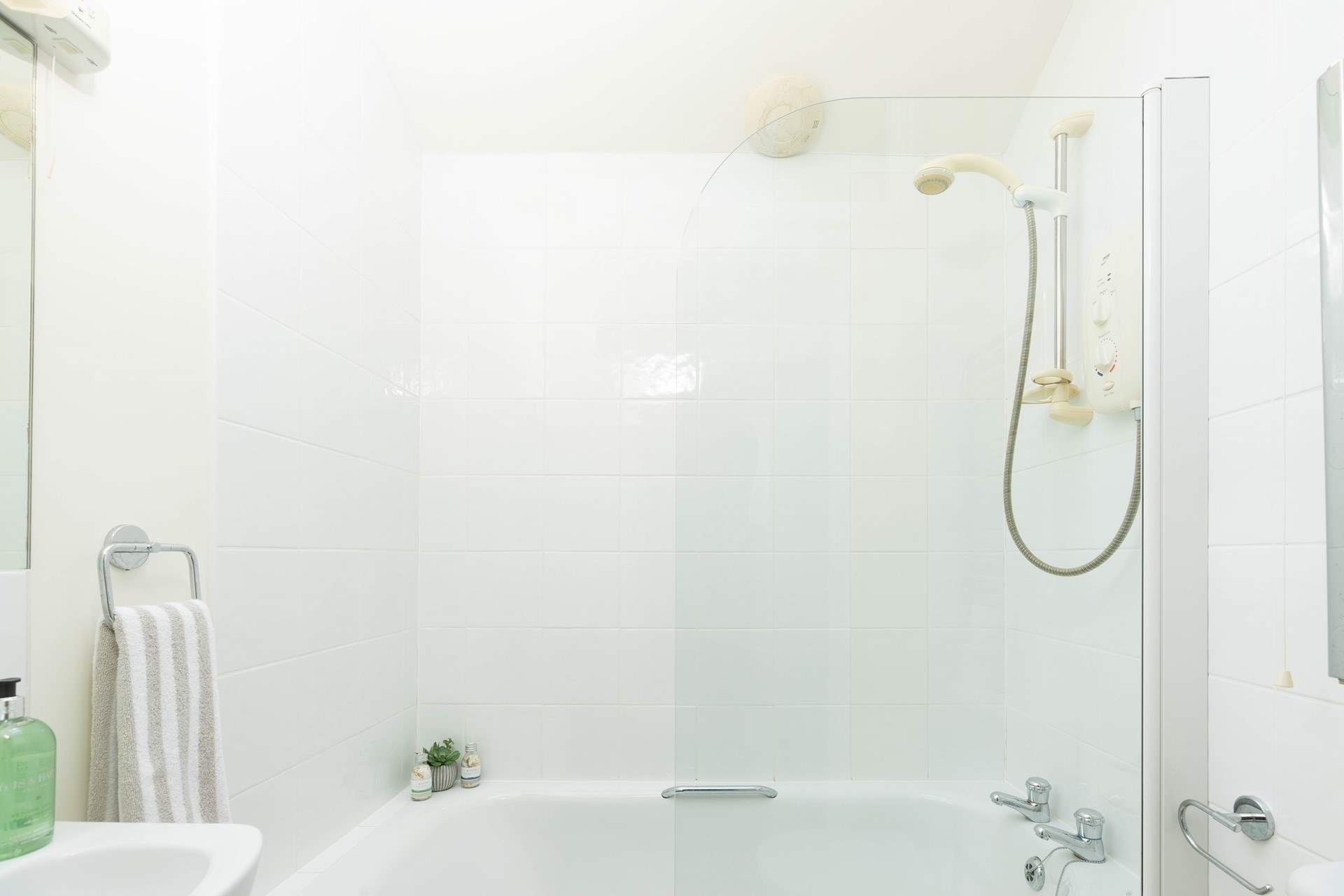 The family bathroom has a bath with shower over.