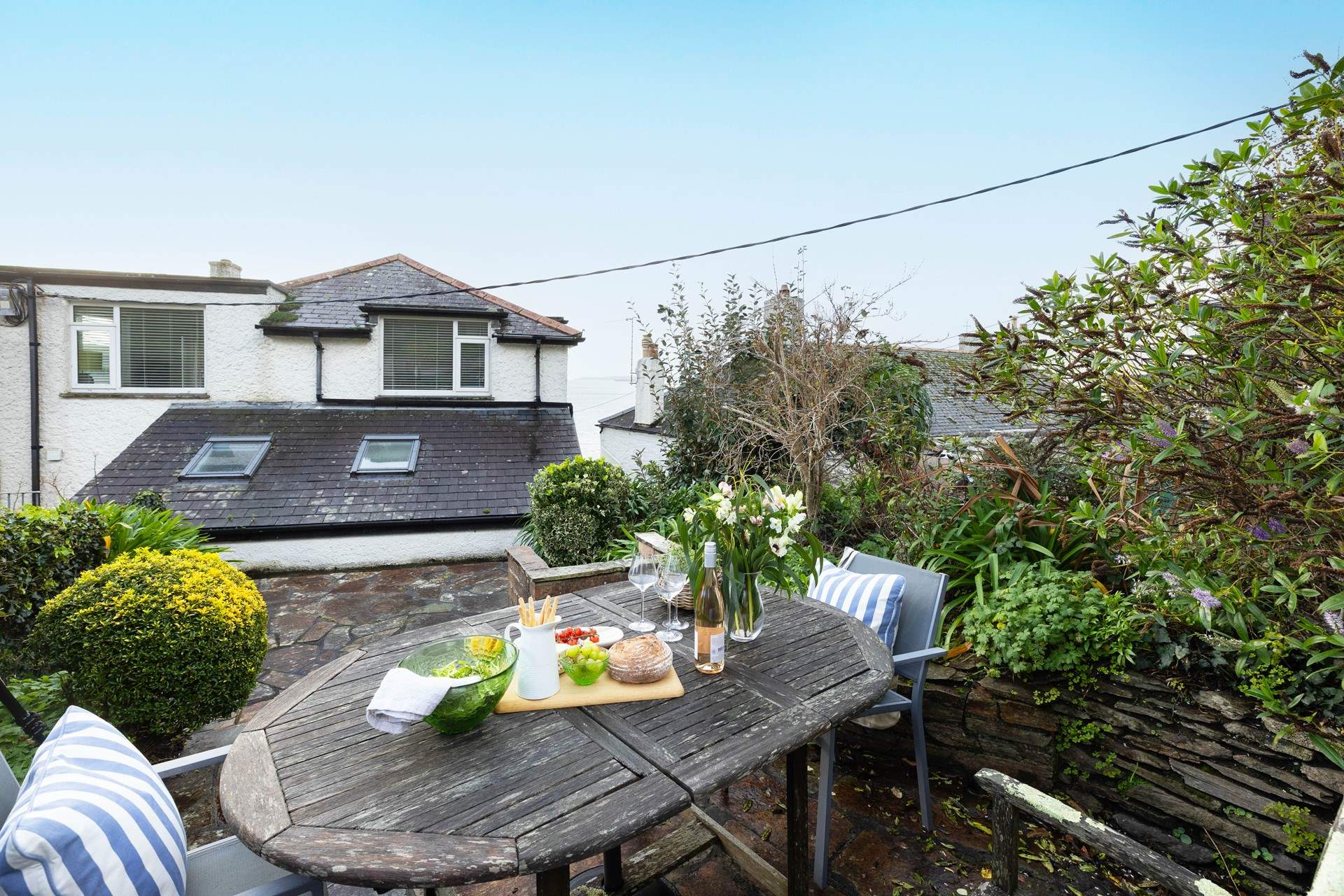 Through the garden gate to the rear, and up a few steps, the patio awaits,  perfect for holiday meals in the fresh air. 