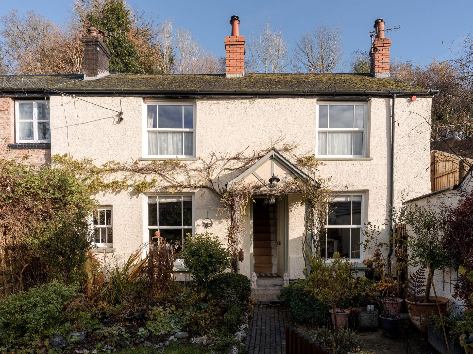 The front garden is split into a lawned area on the left and a patio area to the right.