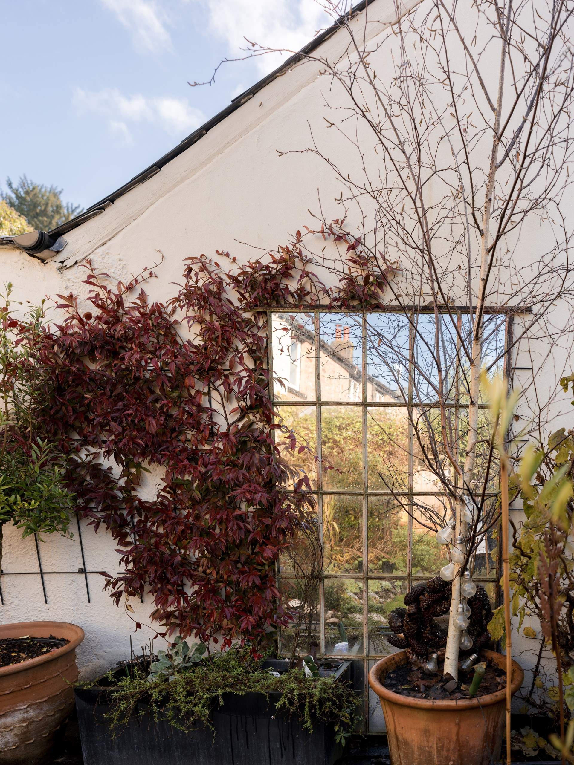 The private outdoor space features a small area of lawn and a lovely curated patio with pieces of architectural salvage and careful planting. You will also find a table and chairs here to enjoy the afternoon and evening sun.