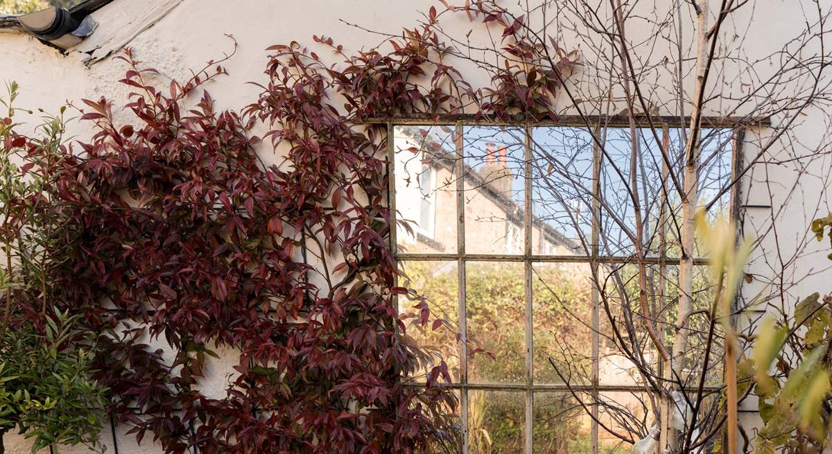 The private outdoor space features a small area of lawn and a lovely curated patio with pieces of architectural salvage and careful planting. You will also find a table and chairs here to enjoy the afternoon and evening sun.