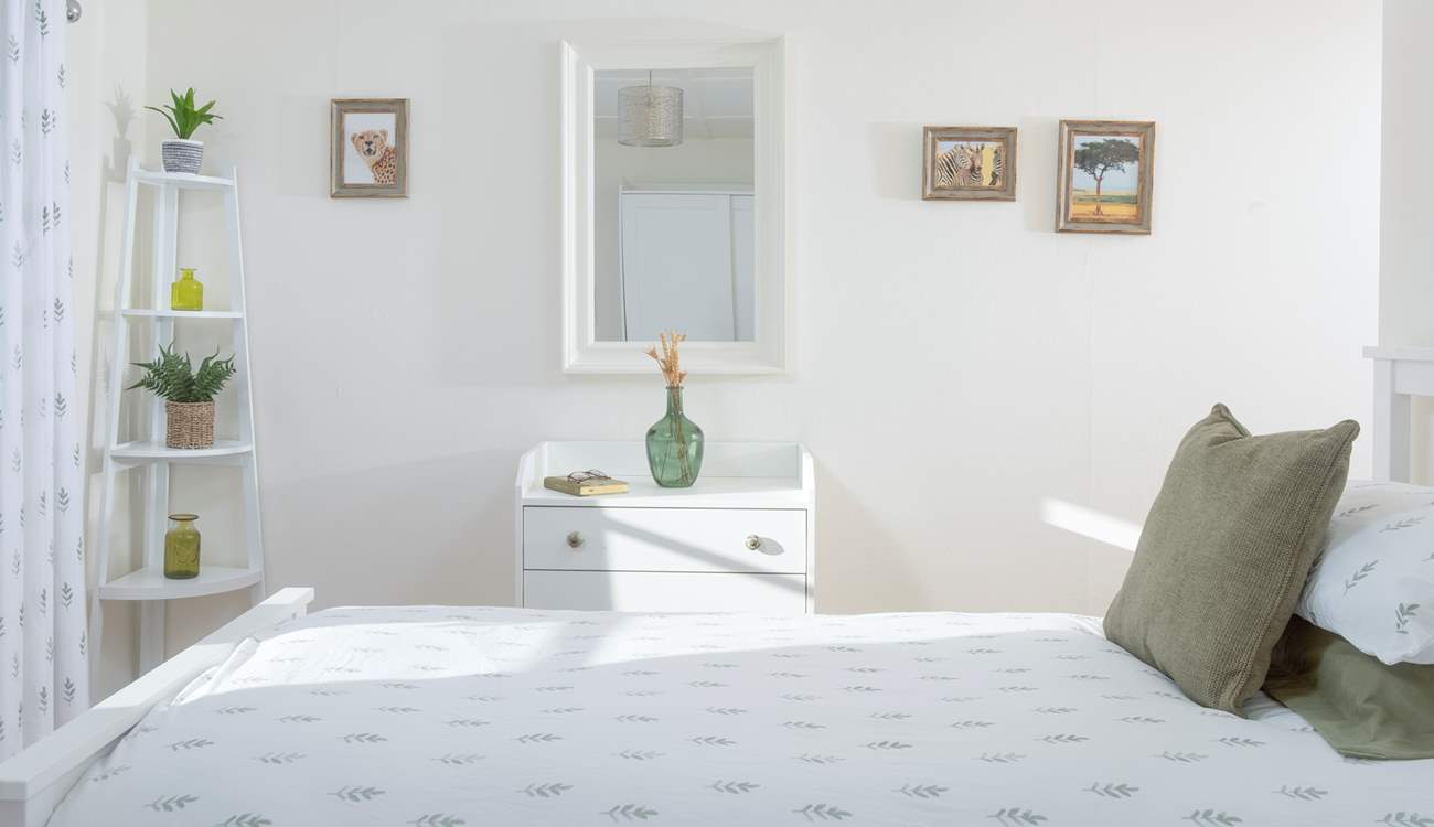A serene twin bedroom bathed in light and gentle tones.