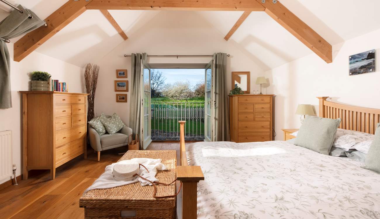 Bedroom 1 is a delight, with its vaulted ceiling and Juliet balcony looking out over the garden.