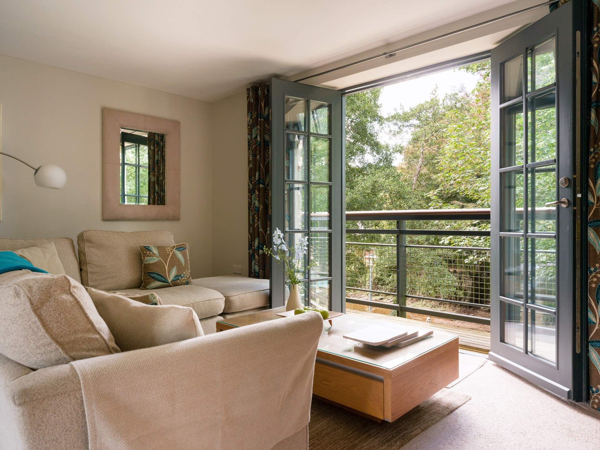 The cosy living-room has a small balcony looking over the river.