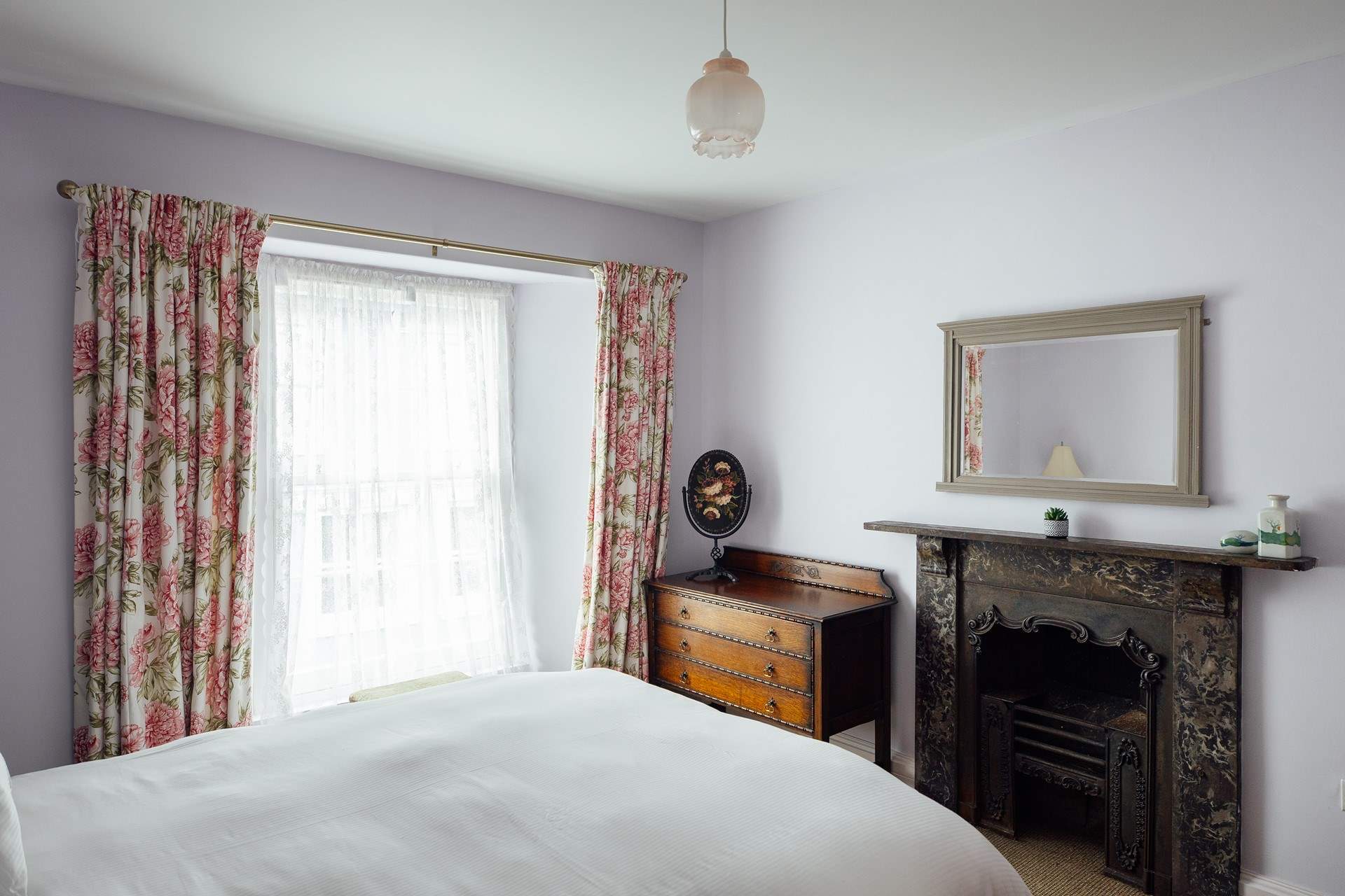Original, gorgeous ornate fireplace in the king-size room located to the front of the house. 