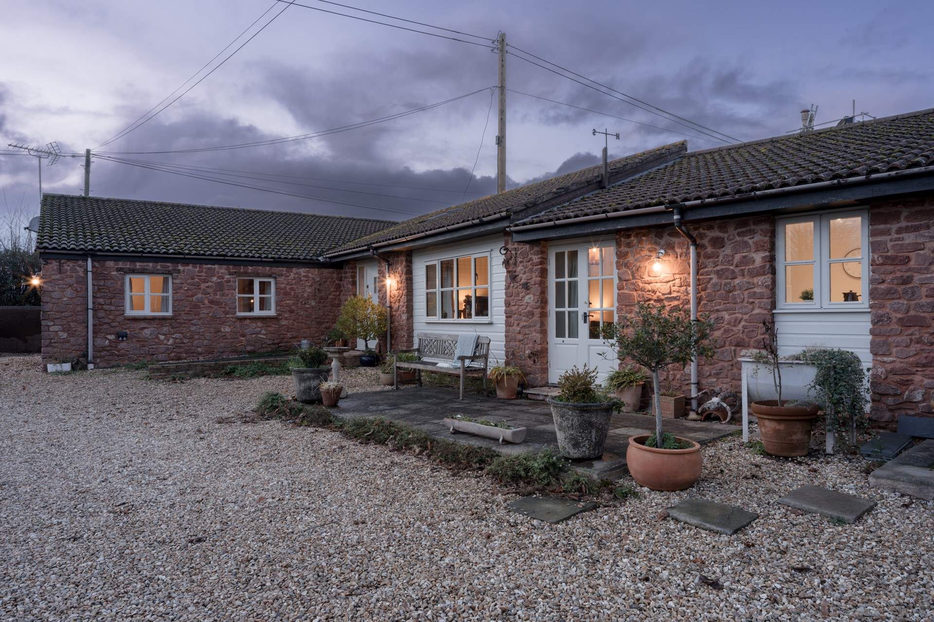 A wonderful private patio runs across more of the property with lovely views over the lawns of the main house. Outdoor chairs and a table are in situ during the warmer months. Note that this area will soon have some privacy screening added.