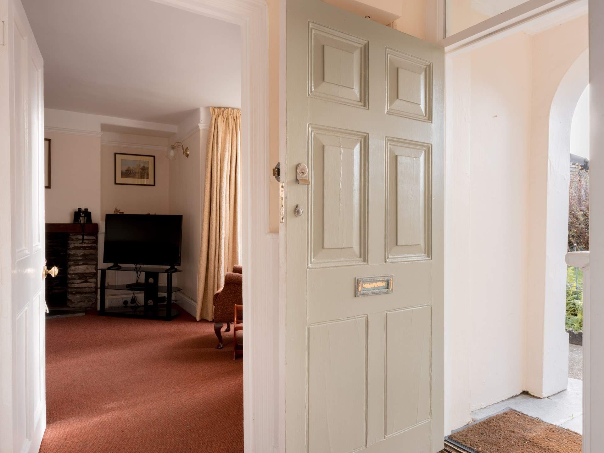 Open the traditional door into a traditional house with a red tiled hallway.