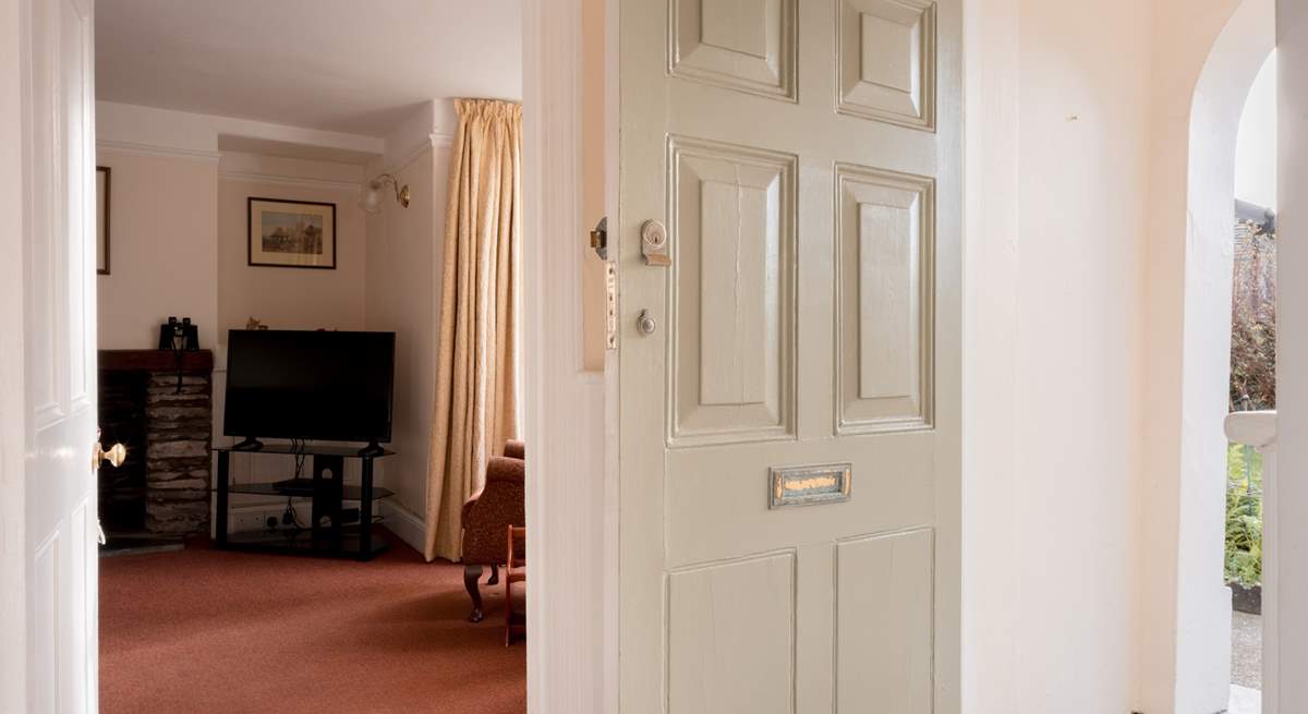 Open the traditional door into a traditional house with a red tiled hallway.