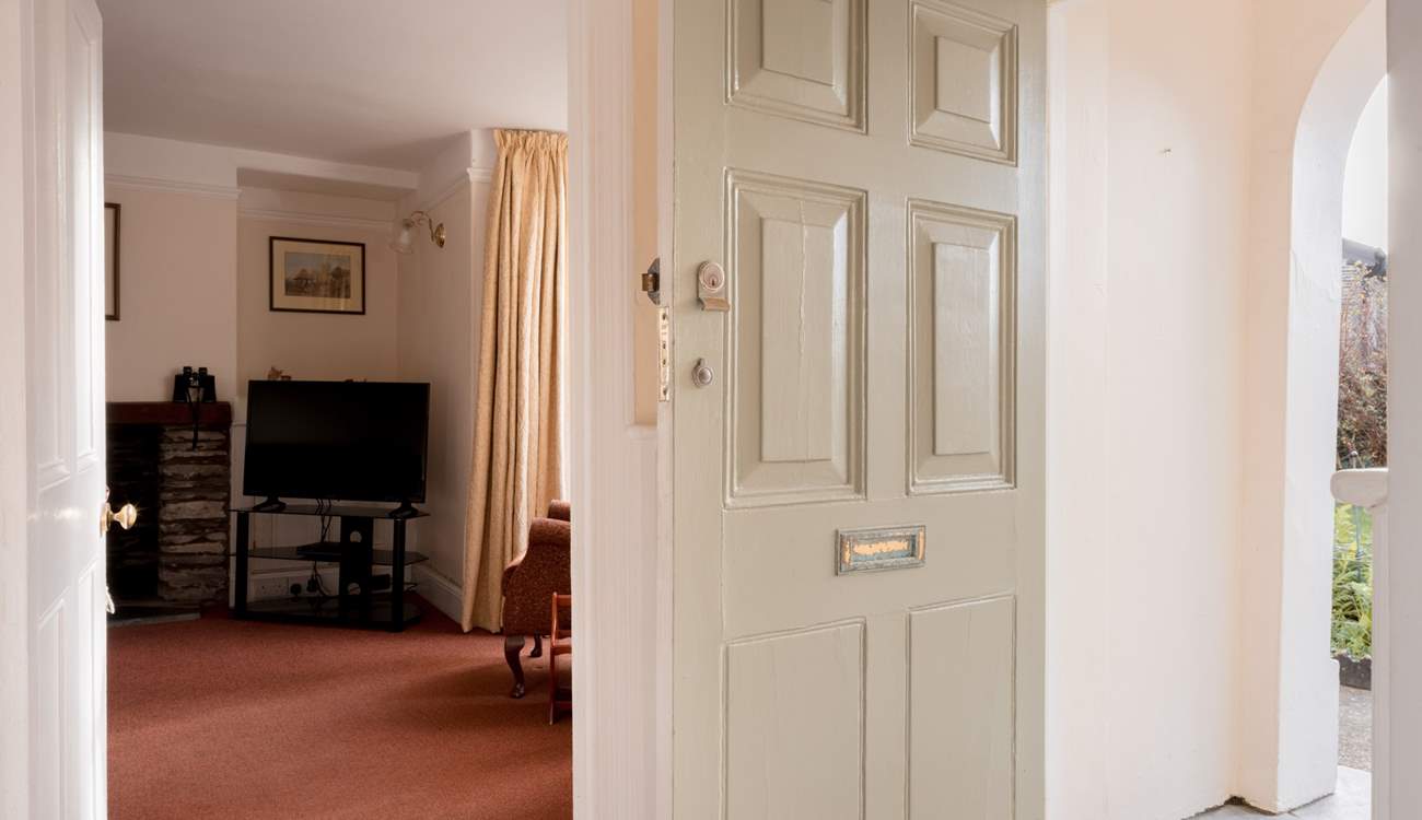 Open the traditional door into a traditional house with a red tiled hallway.