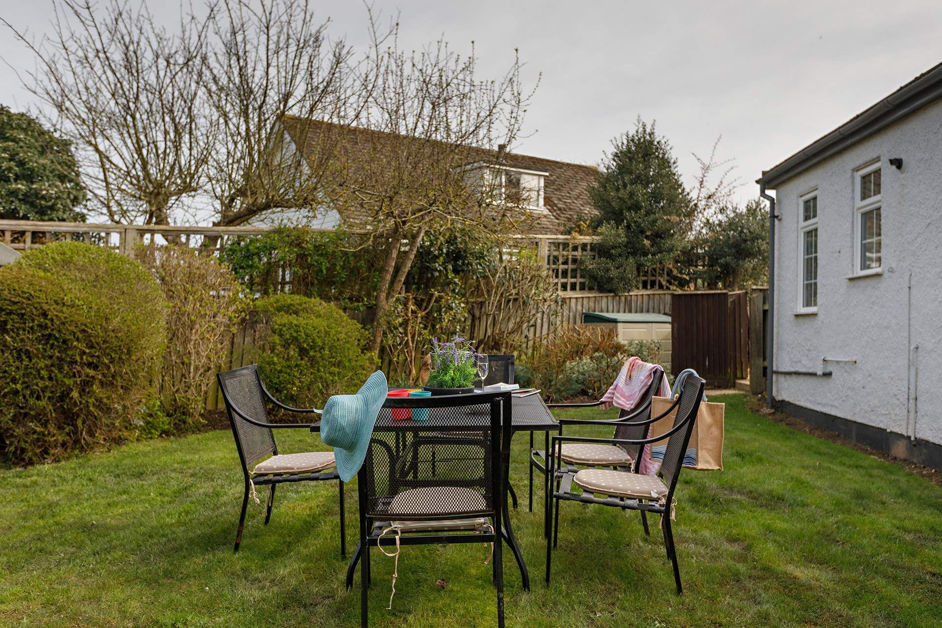 The garden is accessed via a secure gate from the shingle driveway.