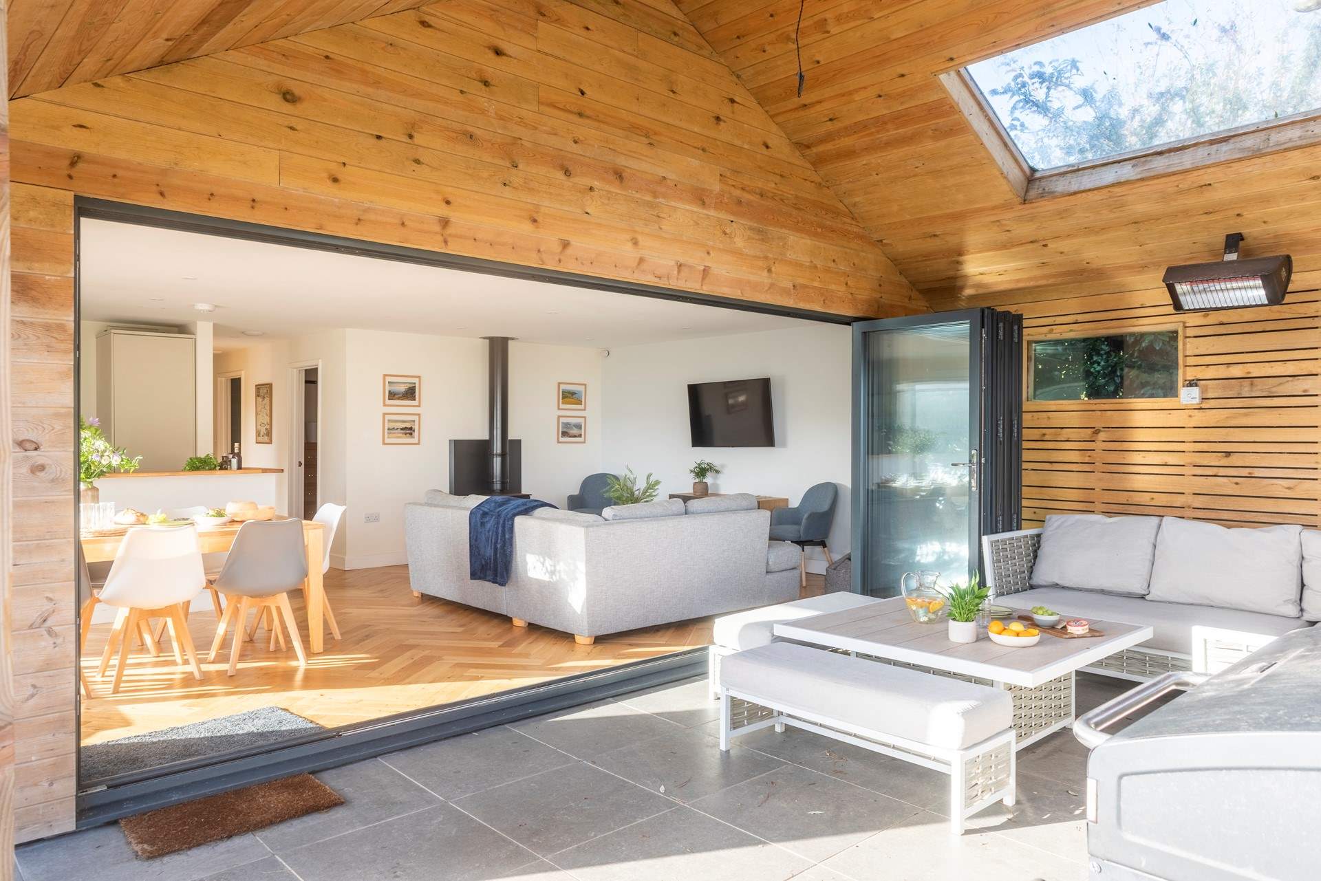 A versatile open plan living space with plenty of room for everyone, extending to a covered patio where guests can unwind, relax or enjoy the fresh air in comfort.