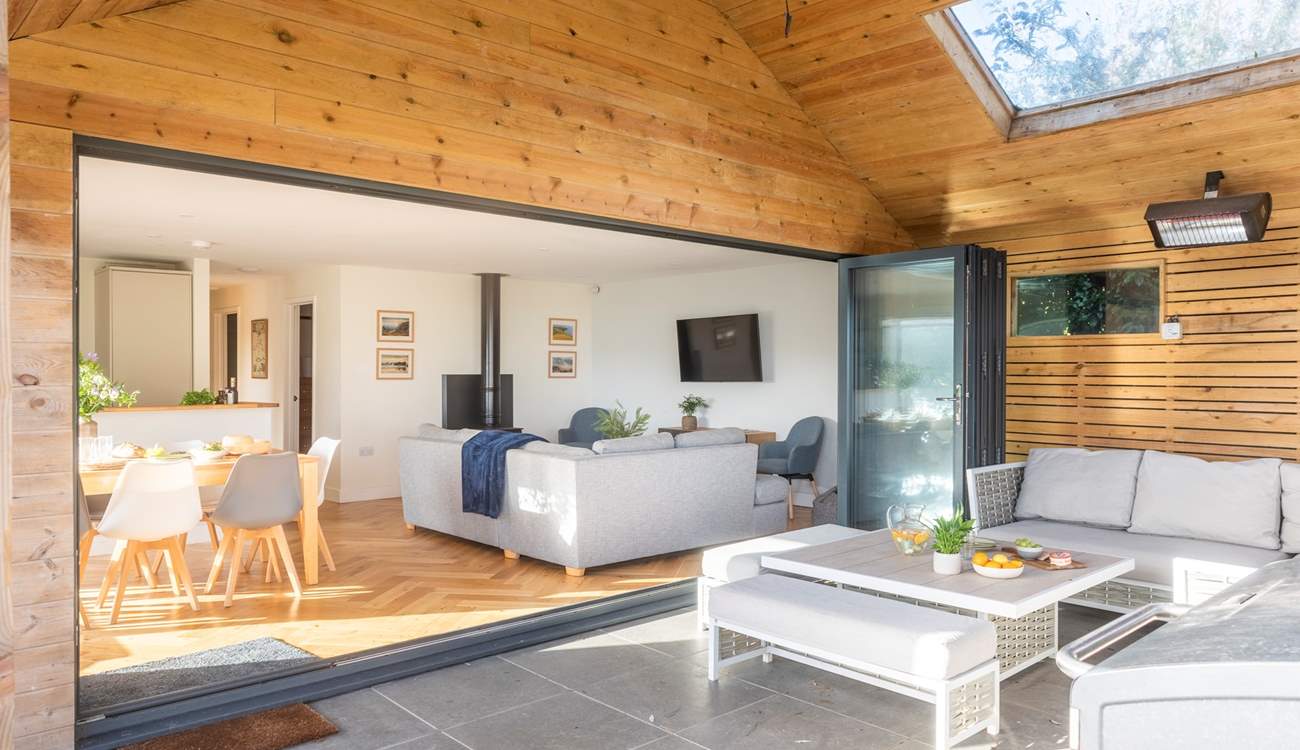 A versatile open plan living space with plenty of room for everyone, extending to a covered patio where guests can unwind, relax or enjoy the fresh air in comfort.