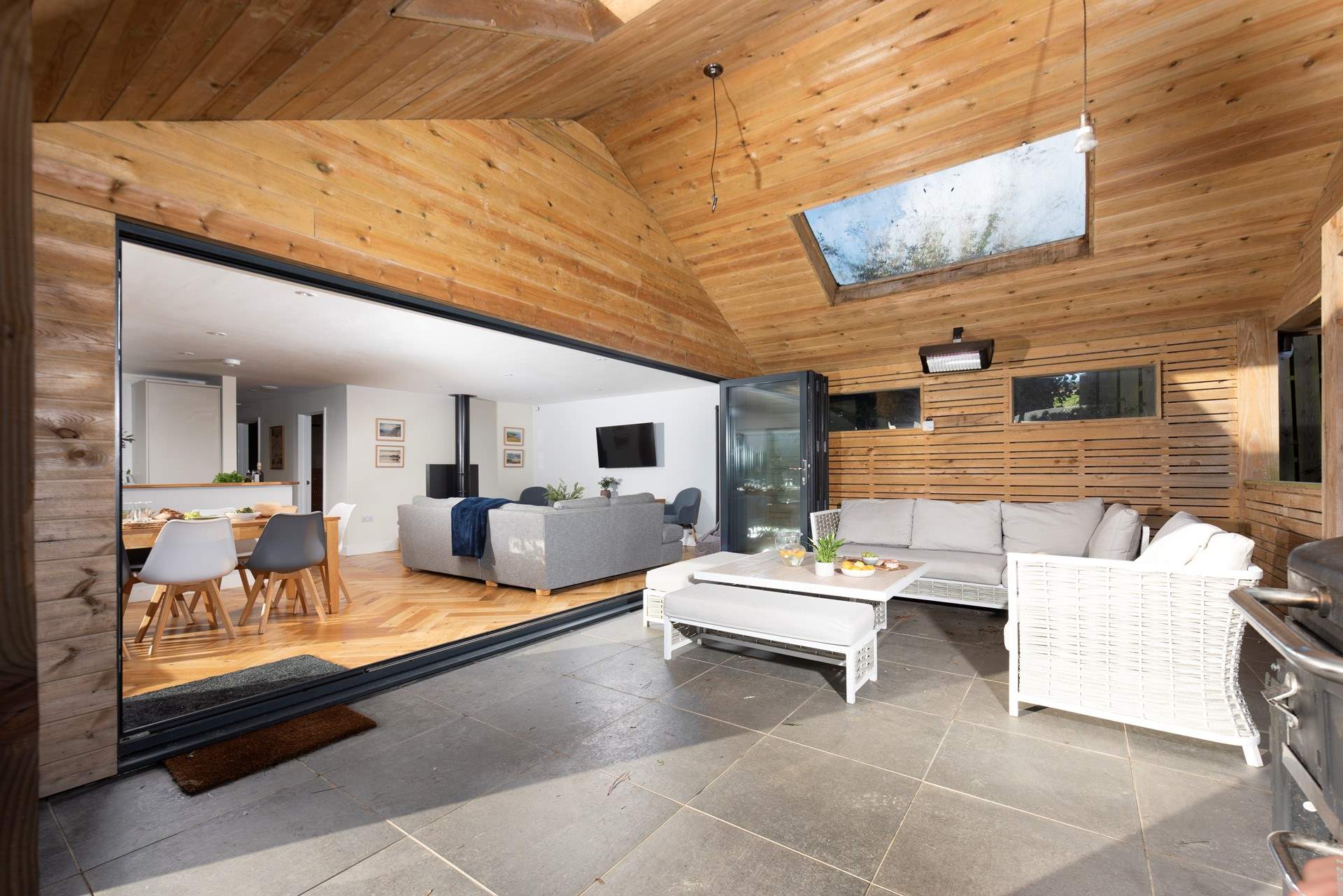 The large bi-fold doors connect the open plan living-room with the covered patio.